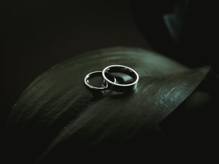 Ringpaar auf grünen Blättern im Dunkeln