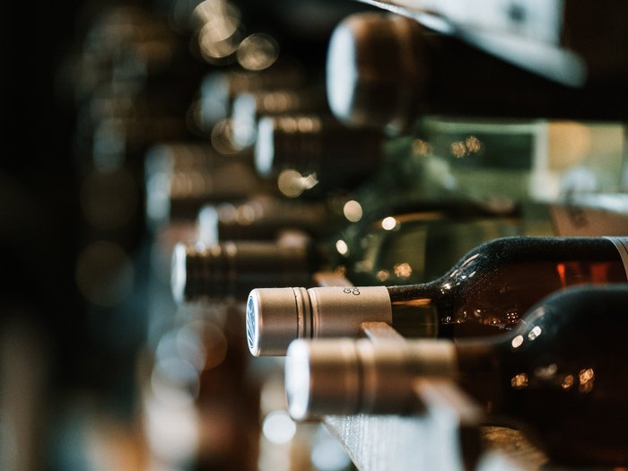 Weinflaschen in Regal mit Tiefenunschärfe fotografiert
